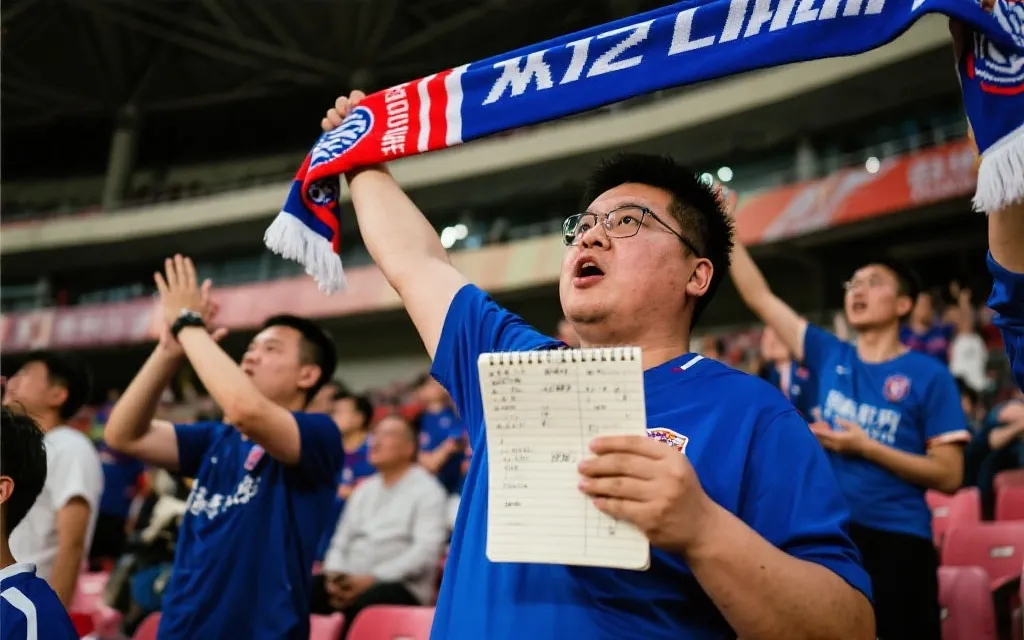 球迷在看台上克制加油的场景：一半热血一半理性